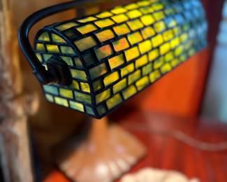 Signed Handel bronze lamp base paired with a beautifully executed leaded glass shade, unsigned but strongly reminiscent of Tiffany Studios craftsmanship. A classic Arts & Crafts period lighting piece featuring rich patina and warm illumination — an elegant addition for collectors and period interiors.