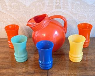 	Orange Ceramic Pitcher With Colorful Glassware