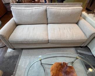 Gently used two-seater sofa with nail head trim