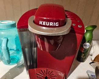 Allot of red counter top appliances and dishware 
Keurig coffee maker $25
