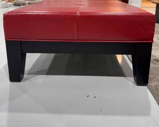 Red Leather Ottoman with Ebonized Wood Base. Measures 31" W x 48" W x 16" H. Photo 1 of 2.