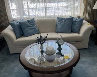 Very clean white sofa with round glass coffee table and matching end tables