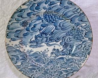 Blue and white porcelain plate featuring an East Asian-inspired dragon and wave motif. This specific design is widely known as the "Sea Dragon" pattern produced by Fitz & Floyd