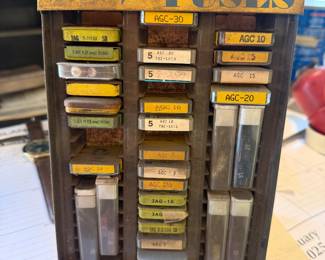 vintage Buss Fuses store counter display case containing various glass tube fuses in tin lithograph boxes. 