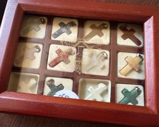 et of 12 semi-precious stone cross pendants displayed in a wooden case. 