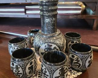Black carved stone decanter with 6 carved stone cups.