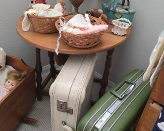 Vintage hard side luggage; primitive drop side oval table; antique hand made baby bonnets and booties