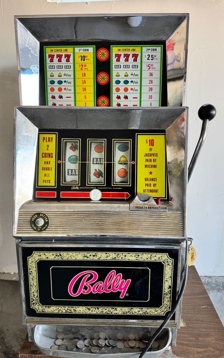 Antique Bally's Nickel Slot Machine.  Has key and opens for access.   Lights (no sound), slot for nickels, arm mechanism, and release of coins all work.  Plug damaged.