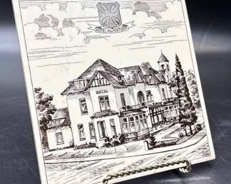 Decorative ceramic tile featuring a linedrawing illustration of the former Hotel Hilfert in Sommeld