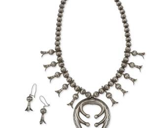 159
A Southwest Navajo sterling silver squash blossom necklace and earrings
Mid-20th century, Diné
Unmarked
A single strand of sterling silver pearls enhanced with ten squash blossoms and finished with a large cast silver naja with stamped accents, as well as a pair of matching squash blossom earrings
3 pieces
Necklace: 22.25" L x 2.625" H ; Earrings: 2" H
109.7 grams
Estimate: $800 - $1,200