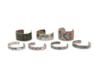 241
A group of Southwest silver and chip inlay cuff bracelets
Mid/late 20th century
Three variously marked for maker: [peyote bird picto for Gibson Gene] / BH [or HB] / AD [conjoined]; one marked for sterling
Seven cuff bracelets in silver and chipped turquoise, coral or greenstone mosaic inlay, in various designs and motifs including a narrow Gibson Gene Navajo/Diné cuff with geometric and stamp work banding, as well as others with Kokopelli as well as zig zag and geometric motifs
7 pieces
Largest: 7.25" total inner C x 1" H, with a 1.5" gap; Smallest: 6" total inner C x 1.375" H, with a 1" gap
184.0 grams gross
Estimate: $500 - $700