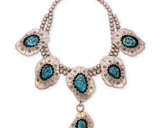 169
A Southwest silver and turquoise squash blossom style necklace
Mid/late 20th century
Stamped with unknown triangle mark verso, further etched: RB071
A double-strand choker necklace with five shaped and stamped silver shadowbox plaques, each with central set turquoise, the center plaque suspending a turquoise pendant
15" L x 4.5" H
173.1 grams gross
Estimate: $800 - $1,200