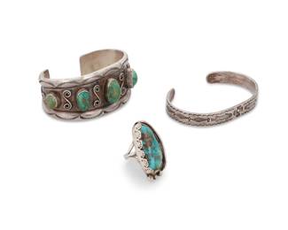 211
A group of Southwest sterling silver and turquoise jewelry
Mid/late 20th century
Most unmarked; one with Old Pawn mark: CAT JC [indistinct]
Three works comprising a tapered cuff with five graduated set turquoise cabochons and silver wire accents and stamped edges, a smaller narrow sterling silver cuff with stamped motifs including fish, and a silver and turquoise ring with an oblong turquoise cabochon, partial shadowbox setting, and silver ball accents and stamped bezel
3 pieces
Cuffs: 6.25" inner C x 1.25" H, with a 1.125" gap and 6.75" inner C x 0.375" H, with a 1.125" gap; Ring: size 7.75; 1.375" H
92.6 grams gross
Estimate: $500 - $700