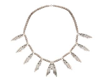 171
A Dwayne Lomayestewa Hopi sterling silver overlay necklace
Dwayne Lomayestewa (b. 20th century; Hopi Pueblo, Coyote Clan from Village of Shungopavi [Second Mesa])
Late 20th century
Stamped with artist's antelope picto cipher / Lomayesteya / [Hopi Guild picto]
Featuring eight single tabs and a double central pendant, all with silver overlay in a stylized avian motif, all suspended on a strand of silver beads
23.5" L x 2" H
89.0 grams
Estimate: $300 - $500