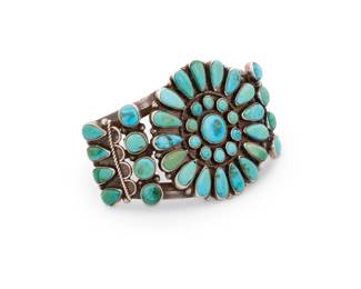 183
A Southwest Zuni Pueblo style sterling silver and cluster set turquoise cuff bracelet
Mid/late 20th century
With etched marks to interior
A three-wire cuff with a central cluster set petit point turquoise roundel and row-set turquoise to shoulders
6.125" total inner C x 1.875" H, with a 1.25" gap
64.8 grams gross
Estimate: $500 - $700