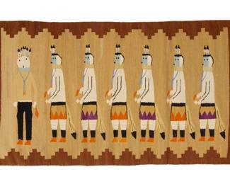 31
A Navajo Yei Bi Chei pictorial textile
Mid-20th century, Diné
Woven in brown, tan, orange, purple, blue, and black wool, with one standing figure and six Yei dancers, with a stepped crenellated border to two sides
31.5" H x 57" W
Estimate: $500 - $700