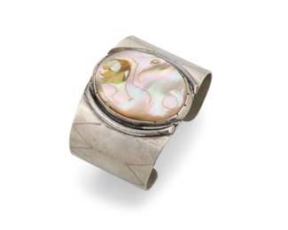 194
A Julius Caesar Southwest style nickel silver and abalone cuff bracelet
Julius Caesar (1910-1982, Pawnee)
Mid/late 20th century
With etched signature: J Ceasar [sic]
A chunky wide cuff featuring a large central set abalone with handmade bezel and with etched zigzag motifs to sides
7" total inner C x 2" H, with a 1.25" gap
87.9 grams gross
Estimate: $200 - $400