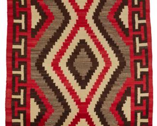 22
A Navajo regional rug
Early 20th century, Diné
Woven in red, cream, natural grey and dark brown/black wool, with stacked stepped diamonds within an elaborate hooked border
83" H x 52.5" W
Estimate: $700 - $900