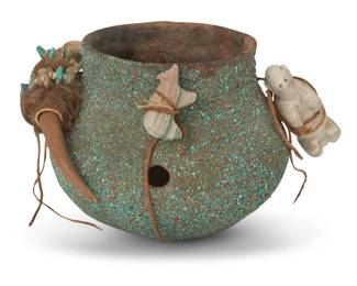 116
A Zuni Pueblo fetish pottery jar
Late 20th century
Unmarked
Encrusted with turquoise and blended sand, adorned with carved stone or carved bone animal fetish figures fastened to the jar with hide straps, each fetish mounted with coral and turquoise offerings
Overall: 5.125" H x 7.375" W x 6.75" D; Largest fetish: 6.125" L
Estimate: $200 - $300