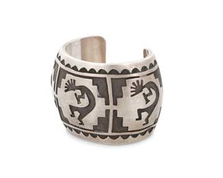189
A Hopi Pueblo style Southwest sterling silver overlay cuff with Kokopelli
Late 20th century
Unknown mark to interior: W
A chunky overlay cuff with three Kokopelli motifs and geometric motifs
6" inner C x 2" H, with a 1.25" gap
113.2 grams
Estimate: $300 - $500