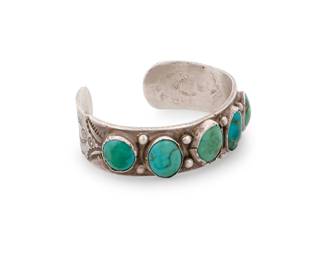 192
A Southwest silver and turquoise cuff bracelet
Mid-20th century
Unmarked
A chunky cuff with five row-set turquoise stones and elaborate stamped terminals
6.75" total inner C x 0.75" H, with a 1" gap
71.6 grams gross
Estimate: $600 - $800