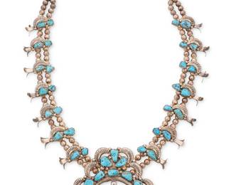 165
A Southwest Zuni sterling silver and turquoise squash blossom necklace
Attributed to Dan Simplicio Sr. (Zuni, 1917-1969)
Mid-20th century
Unmarked
A chunky necklace with a large central stone-set naja with applied silver balls and silver crescent accents, and with fourteen blossoms, all set to double-strand of silver beads
33" L x 3.5" H
313.1 grams gross
Estimate: $1,800 - $2,200