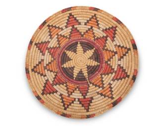68
A large polychrome Navajo wedding basket
Late 20th century, Diné, attributed to the Holiday family
A coiled tray with a central starburst surrounded by concentric rings of stepped starburst motifs
3" H x 21.5" Dia.
Estimate: $400 - $600