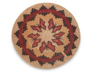 65
A polychrome pictorial Navajo wedding basket
Late 20th century, Diné, attributed to the Holiday family
A coiled tray with five central butterfly motifs surrounded by a stepped starburst band
2.75" H x 16.5" Dia.
Estimate: $400 - $600
