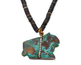 180
An early Southwest Pueblo turquoise fetish necklace
Early 20th century
Comprising a large carved turquoise fetish animal pendant with silver foot suspended from a single strand of sinew-strung black shell disc beads
21.5" L x 1.5" H
66.9 grams gross
Estimate: $500 - $700
