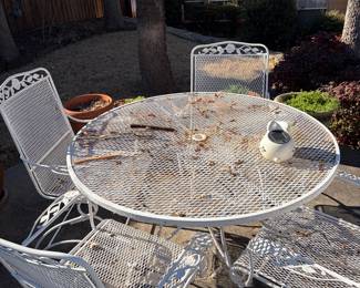 Wrought iron round white patio table with four rocking chairs