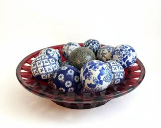 Blue and White Ceramic Balls in Red Bowl
