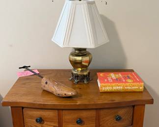Nice bedside table, brass lamp, art, books, shoe tree