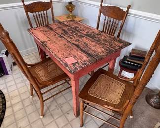 Primitive pink chippy table, vintage oak cane seat chairs, brass lamp with milk glass shade