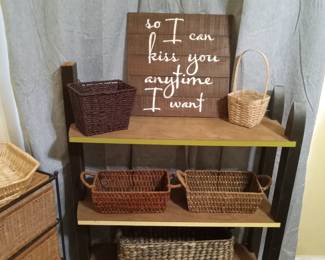 Bookshelf with baskets and sign.