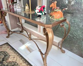 Gold-toned metal console table with a beveled glass top. Entry table
