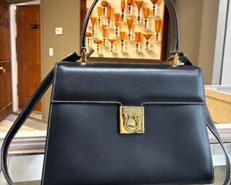 Salvatore Ferragamo Gancini Handbag Beautiful black leather bag featuring Ferragamo’s iconic gold clasp and structured silhouette. Sophisticated Italian craftsmanship.