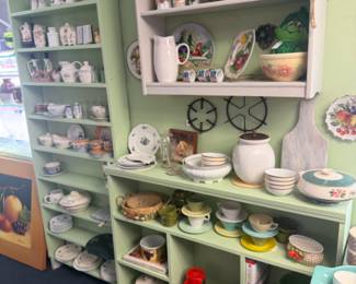 kitchen area is full with all kinds of dishware, plates, canisters, plates and more