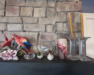Parrot figurine and silver candlesticks on mantel