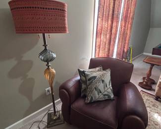 Leather club chair with brass floor lamp, red drum shade, silk curtains