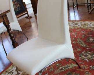 four modern vinyl and chrome chairs