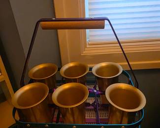 Set of metal drinking glasses in holder