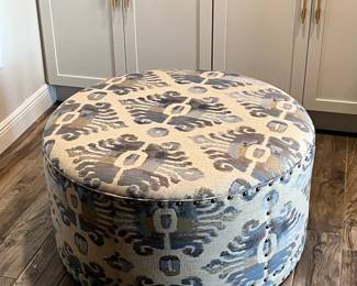 Round Upholstered Ottoman with Ikat Pattern and Nailhead Trim