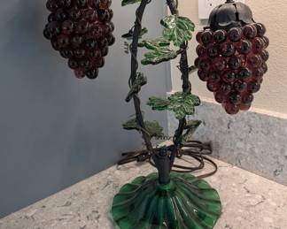 Grape Cluster Lamp: Unique vintage-style stained glass grape cluster lamp resting on a green fluted base.