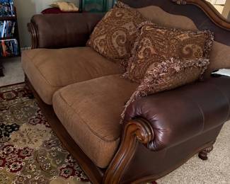 Leather couch and rug with several matching smaller rugs