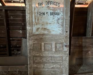 Wooden door with glass window adv 
Law offices of John Bryan 