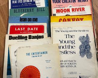 vintage sheet music, including iconic songs like "Moon River," "The Entertainer," and "Blueberry Hill."