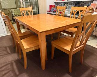 Beautiful dining table with built in extension leaf and six matching dining chairs, offered in like new condition. The table expands easily with self storing leaf.