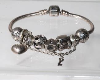 .925 Sterling Silver Designer Pandora Bracelt with 8 additional sterling silver Pandora charms to include a truck, lock, best friend, and other other, approx 7" long and weighs 35.9 total grams, with the charms, very high retail value.