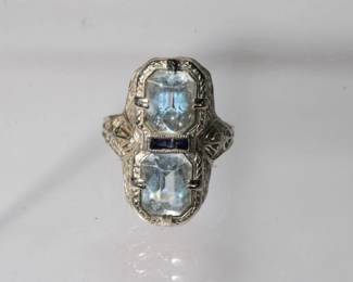 14kt white gold Art Deco Ring that features two emerald cut aquamarines each approx 2ct for a total of 4ctw, they are separated by two small sapphires one of which has a small chip that can be seen under magnification, size 6, 3.9 grams total weight