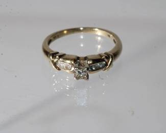 10kt yellow gold Diamond Ring, center diamond is prong set princess cut approx .15ct with 2 more round diamonds on each side total weight for all diamonds is approx .25ctw, size 6.75, 2.7 grams total weight